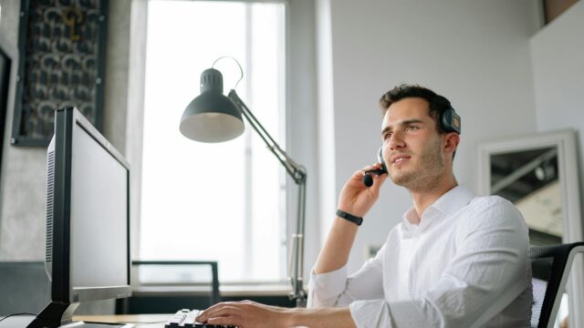 Lawyer virtual receptionist wearing headset while working at computer in legal office setting
